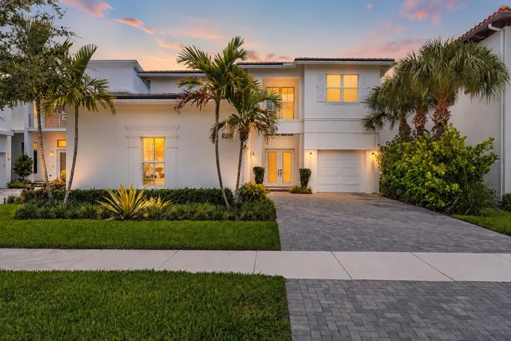 Front exterior view at dusk with garage and landscaped entrance