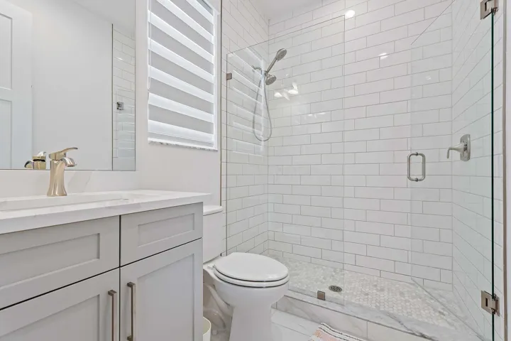 Bathroom with subway tile shower and gray vanity