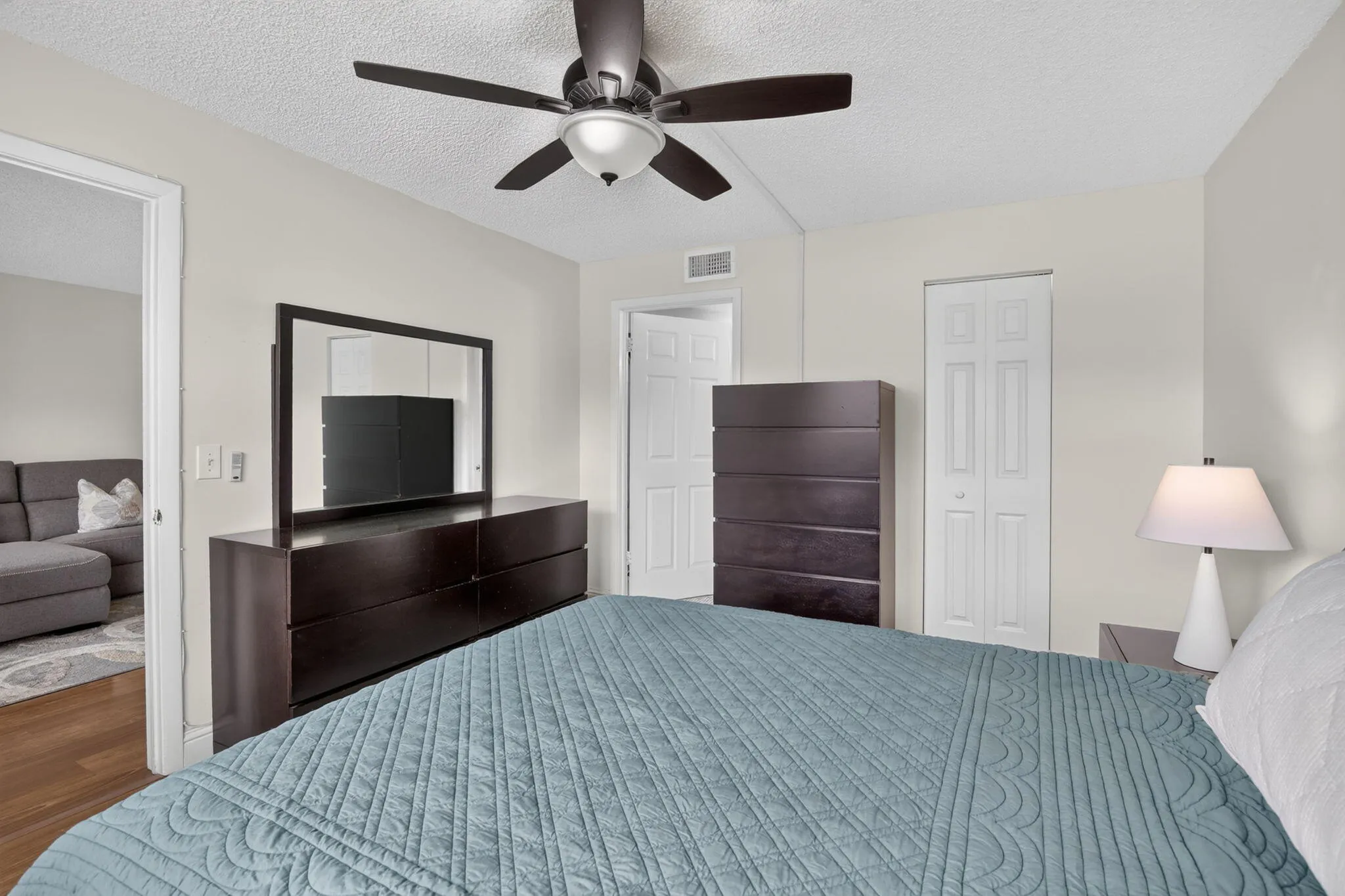 Neutral wall paint throughout, textured ceiling, ceiling fan with integrated lighting, bi-fold doors to the spacious walk-in closet