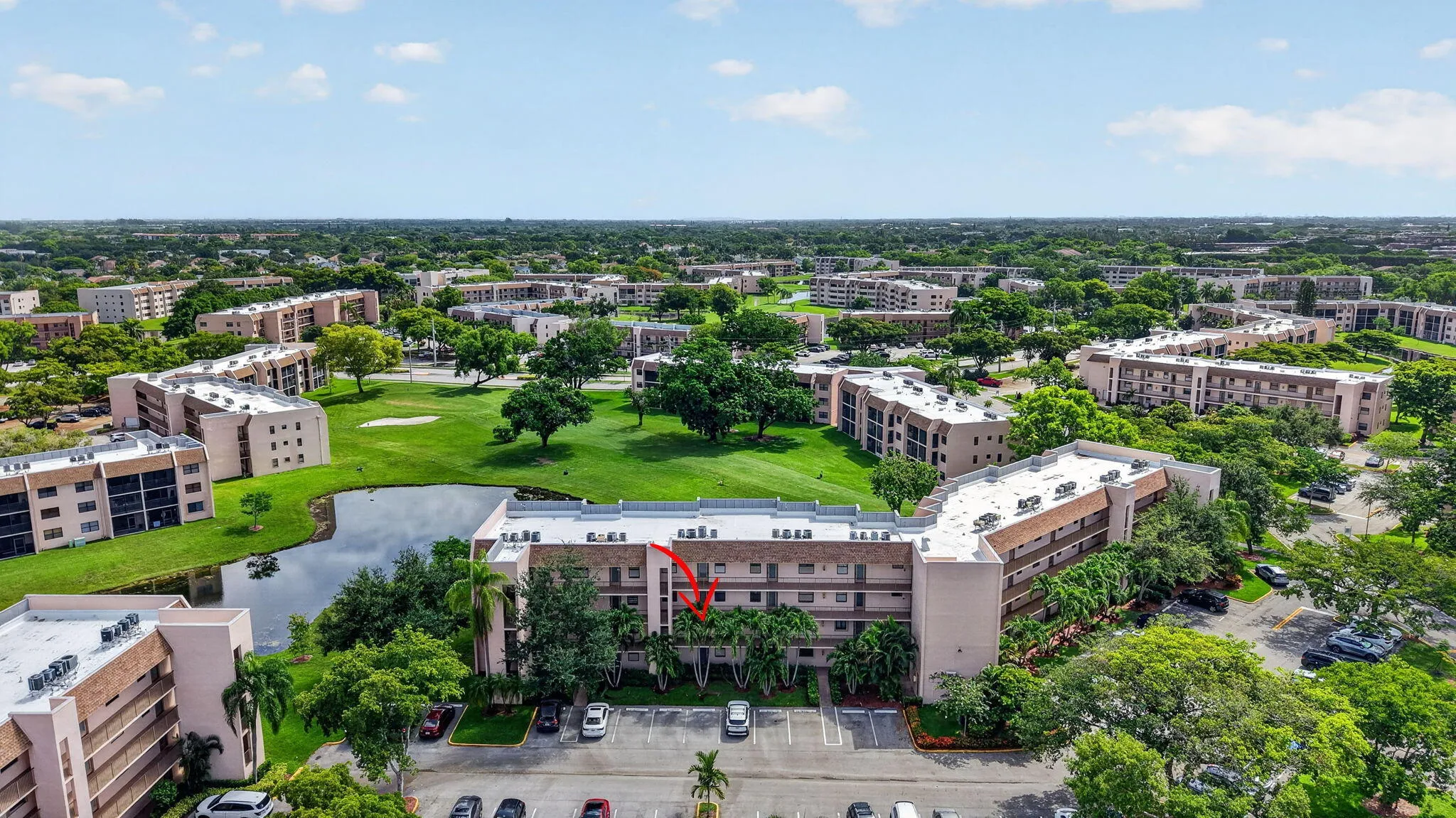 Multi-story residential complex featuring a neutral-toned exterior, balconies, and multiple windows