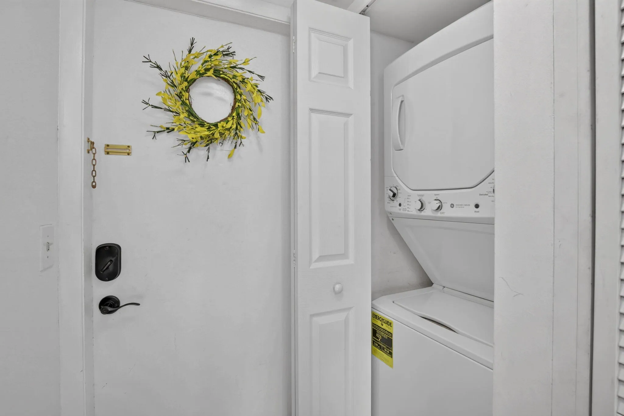 Stackable GE washer and dryer unit, featuring white finishes and top-mounted controls