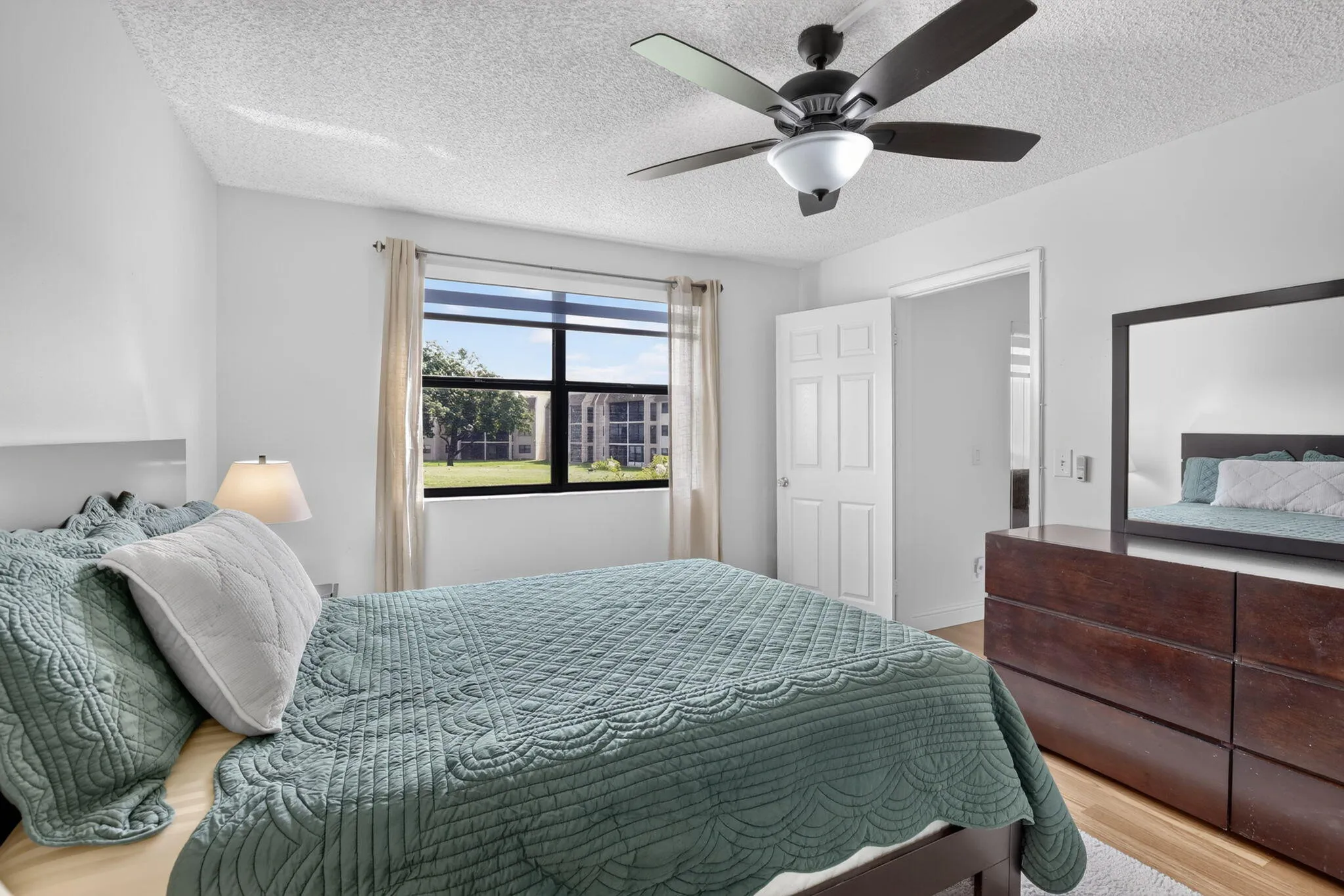 Primary Bedroom featuring a large window, light-toned walls, and laminate flooring
