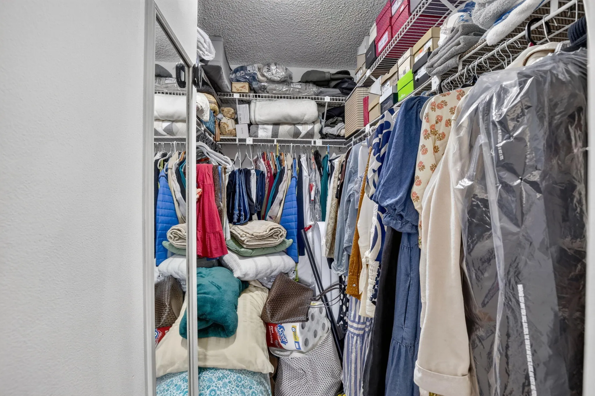 Spacious walk-in closet featuring wire shelving, and multiple hanging rods