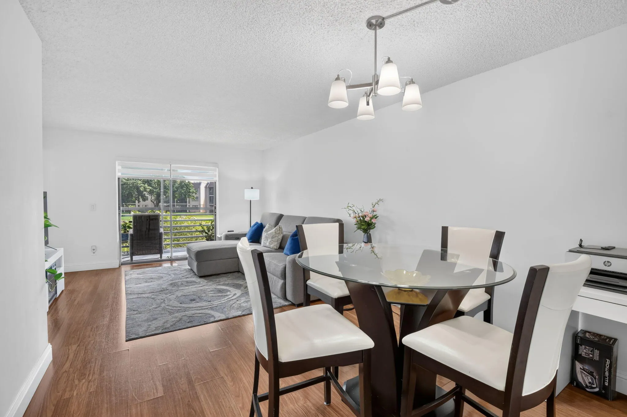 Open-concept living space featuring laminate flooring, and a contemporary chandelier