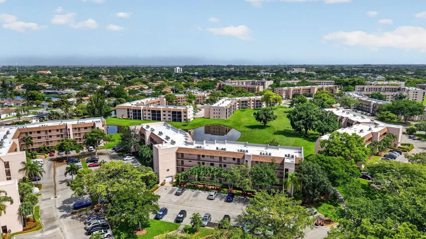 Expansive community featuring multiple residential buildings, abundant green space, a central , mature landscaping, and ample parking