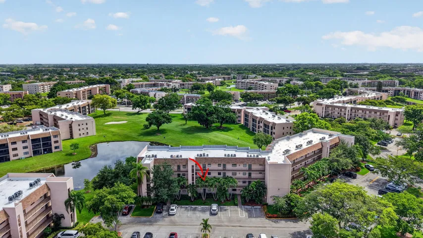 Multi-story residential complex featuring a neutral-toned exterior, balconies, and multiple windows