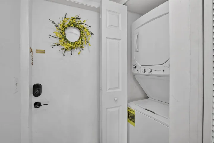 Stackable GE washer and dryer unit, featuring white finishes and top-mounted controls