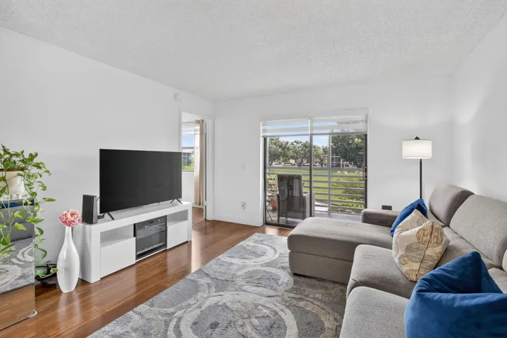 Spacious room featuring laminate flooring, flooded with natural light through sliding glass doors