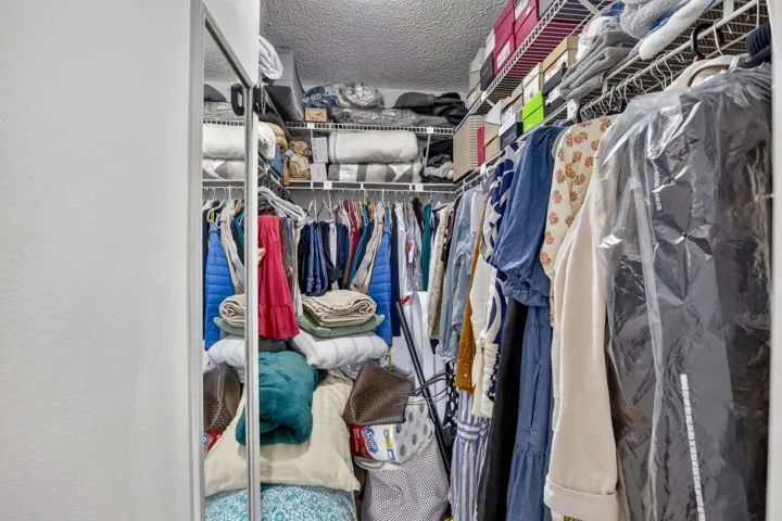 Spacious walk-in closet featuring wire shelving, and multiple hanging rods
