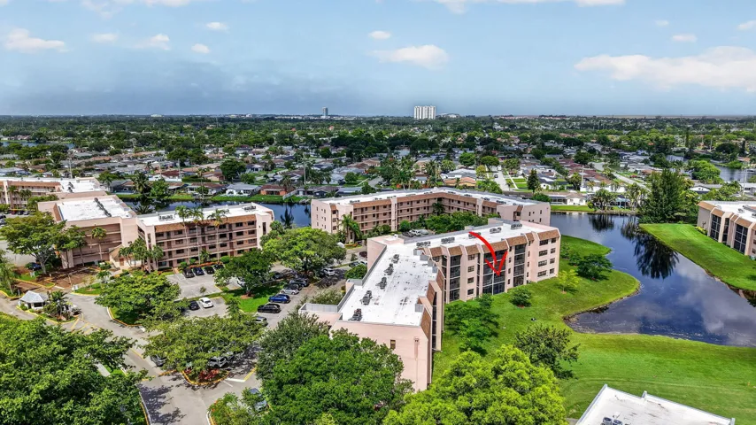 Aerial perspective showcasing a multi-story residential building with balconies and a waterfront setting