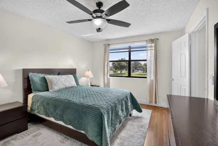 Primary Bedroom featuring a large window, laminate flooring, and a ceiling fan with integrated lighting