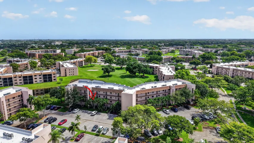 Multi-story residential building featuring balconies and a surrounding golf course