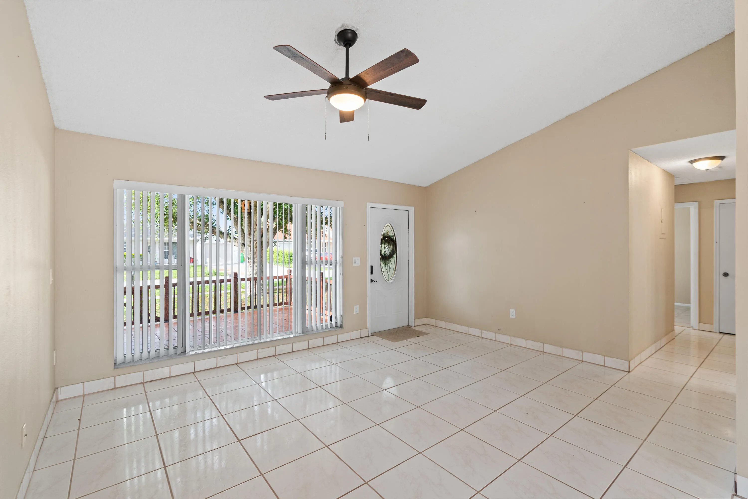 Spacious living room with volume ceiling and large picture window at the front of the house.