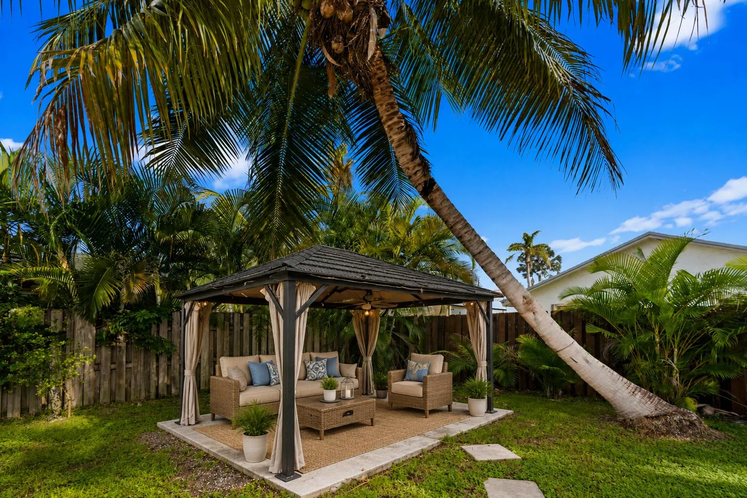 Cozy gazebo under the palm trees create a relaxing seating area.