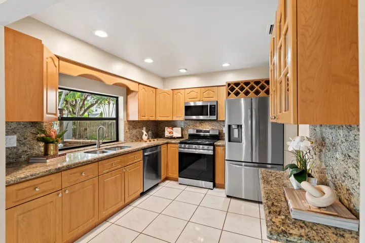 The kitchen features granite countertops, natural gas cooking, and 4 years new Samsung stainless steel appliances.