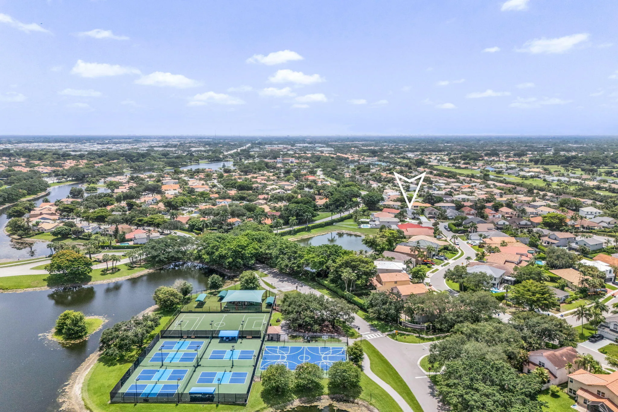 Aerial perspective showcasing a residential community with water features and mature landscaping