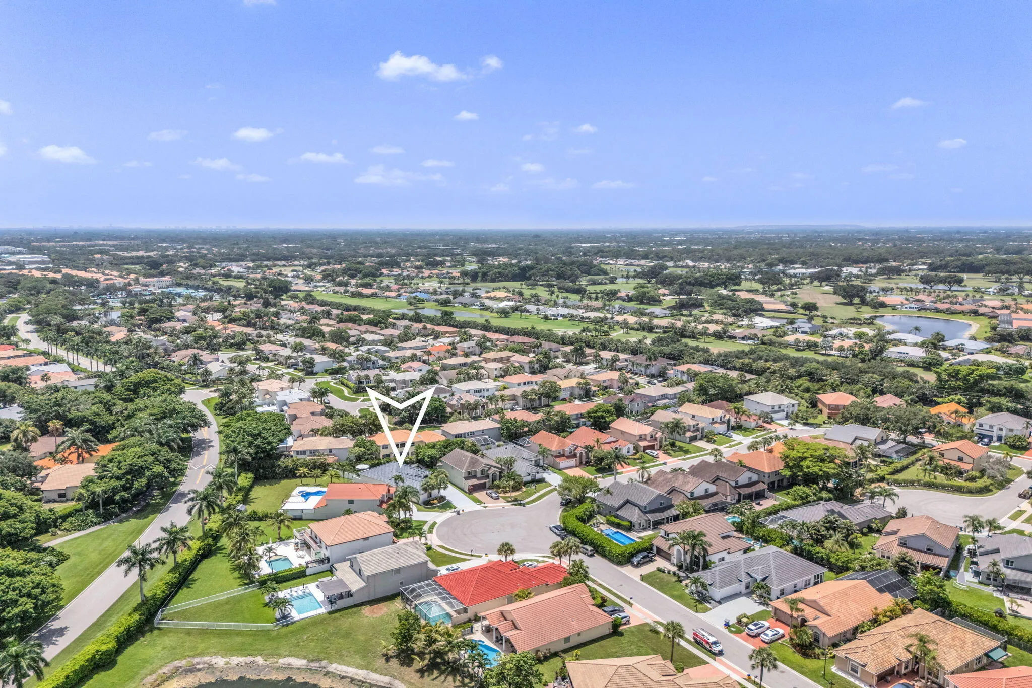 Aerial perspective showcasing a residential community with abundant mature trees and various property styles