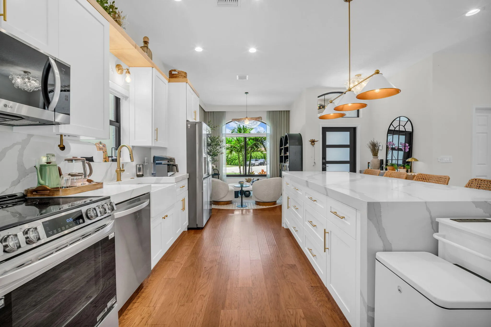 Open-concept kitchen featuring an expansive island with a waterfall countertop and integrated cabinetry