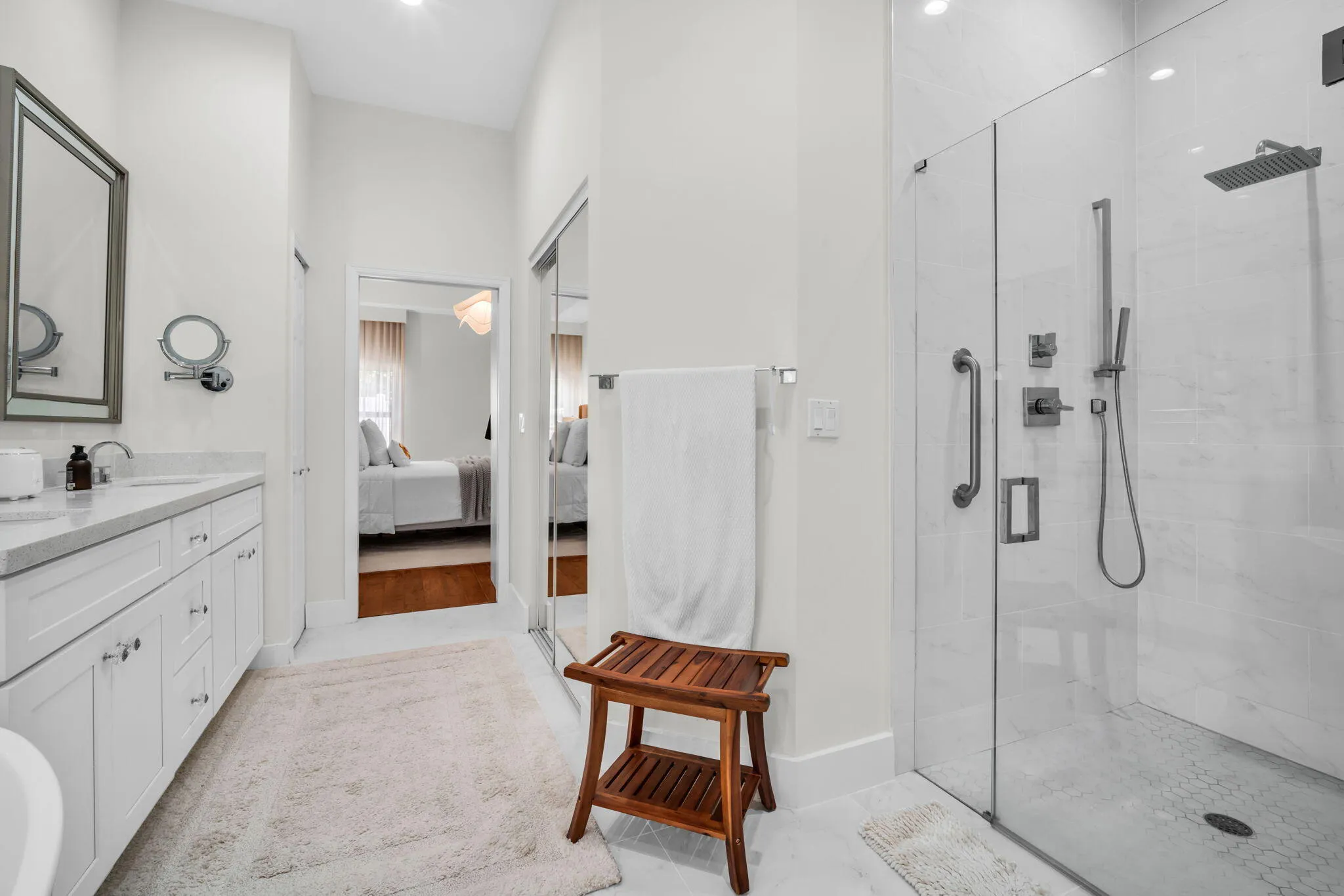 Modern bathroom featuring a frameless glass shower enclosure with a rainfall showerhead and hand sprayer