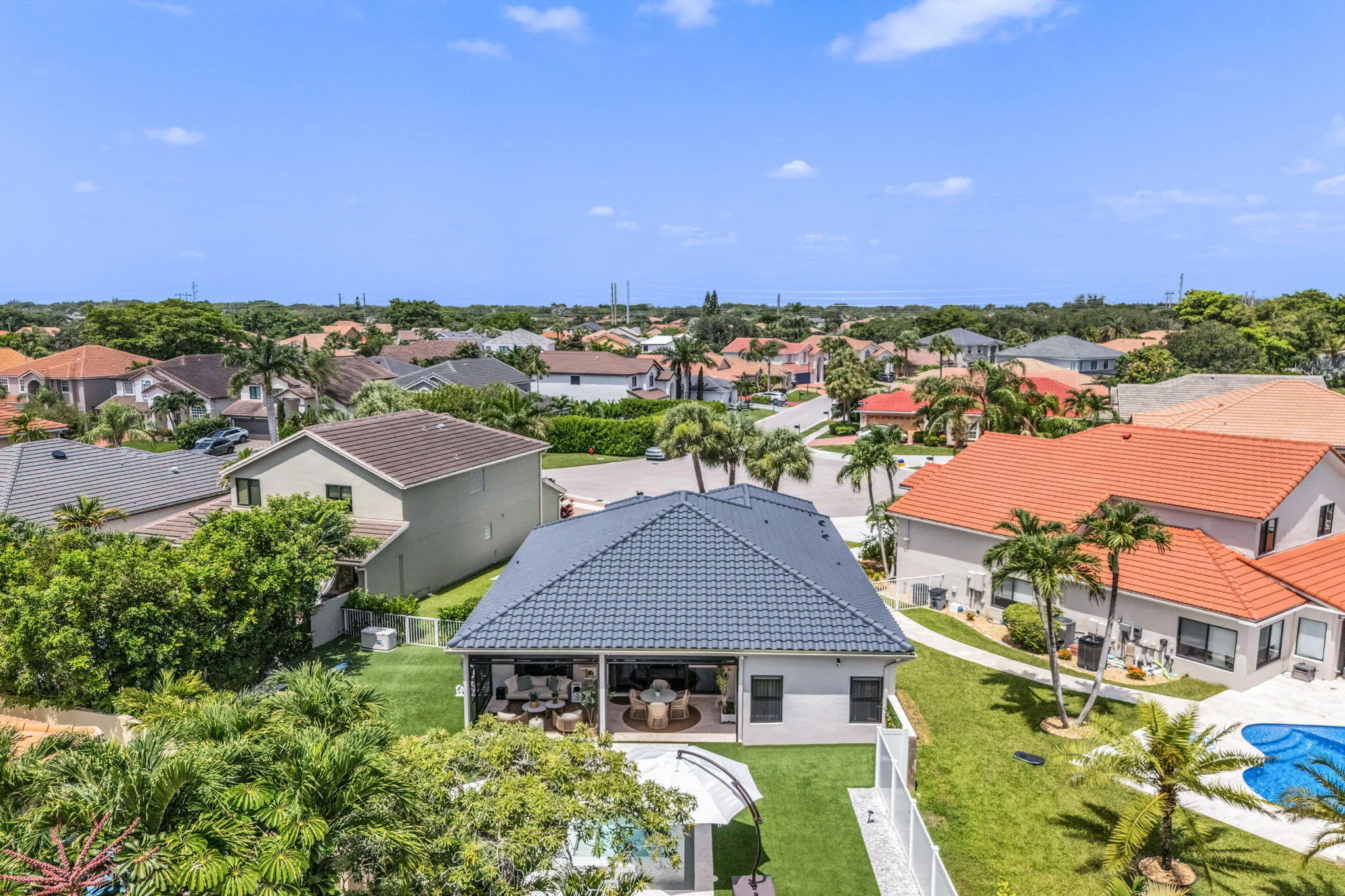 Property featuring a dark tile roof and a covered outdoor living area