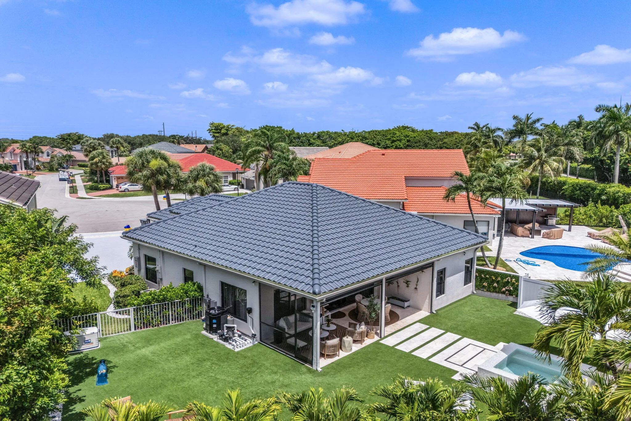 Contemporary residence featuring a gray tile roof and a screened-in patio
