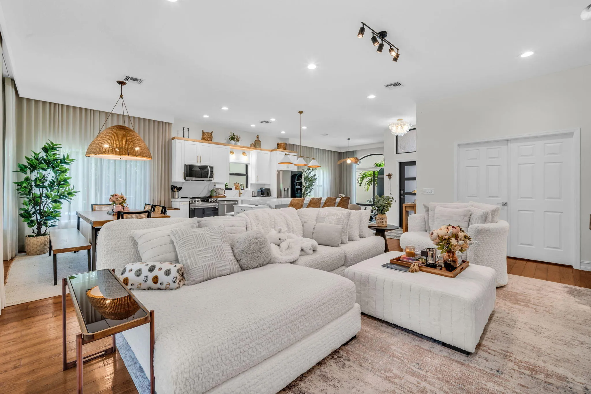 Open-concept living space featuring wood-finish flooring, recessed lighting, and a modern track light fixture