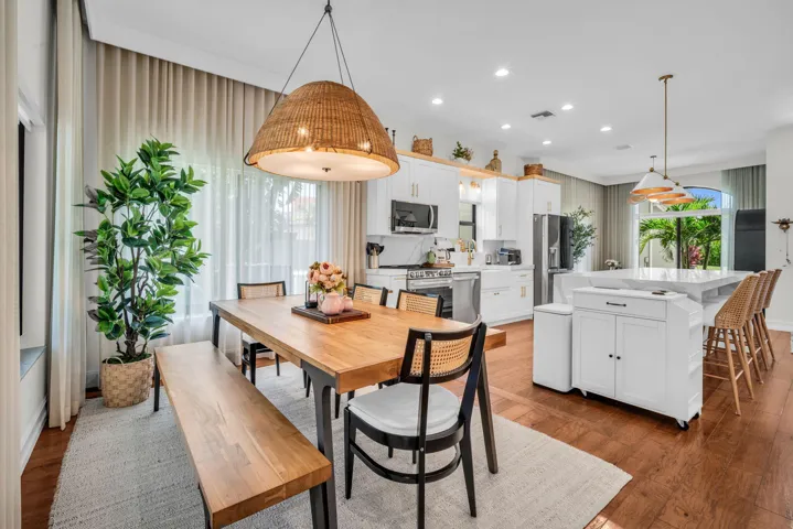 Spacious open-concept kitchen and dining area featuring rich wood-finish flooring