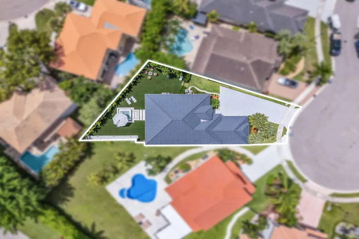 Contemporary residence with a dark gray metal roof and a spacious paved driveway