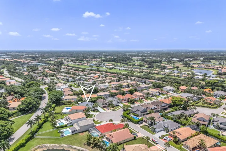 Aerial perspective showcasing a residential community with abundant mature trees and various property styles