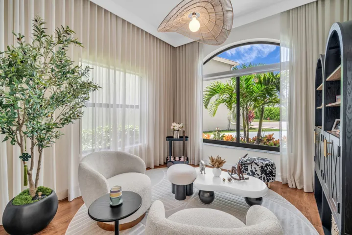 Arched window with black framing and tropical landscaping