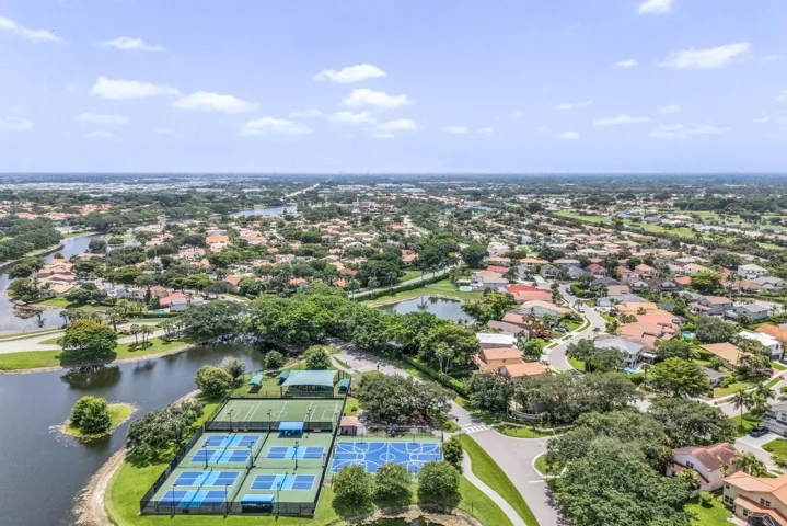 Aerial perspective showcasing a residential community with abundant mature trees and various property rooflines