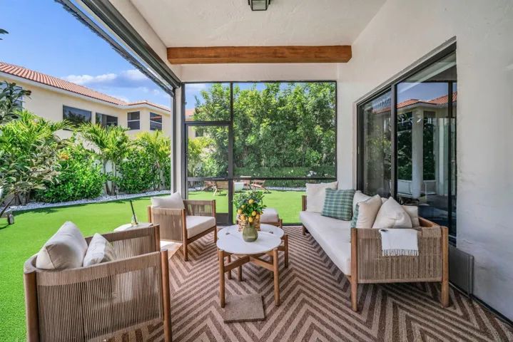 Screened patio featuring a wood-beam ceiling accent and large format sliding glass doors