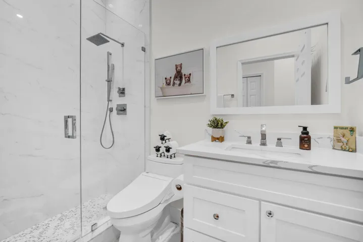 White vanity with a rectangular undermount sink and polished chrome faucet
