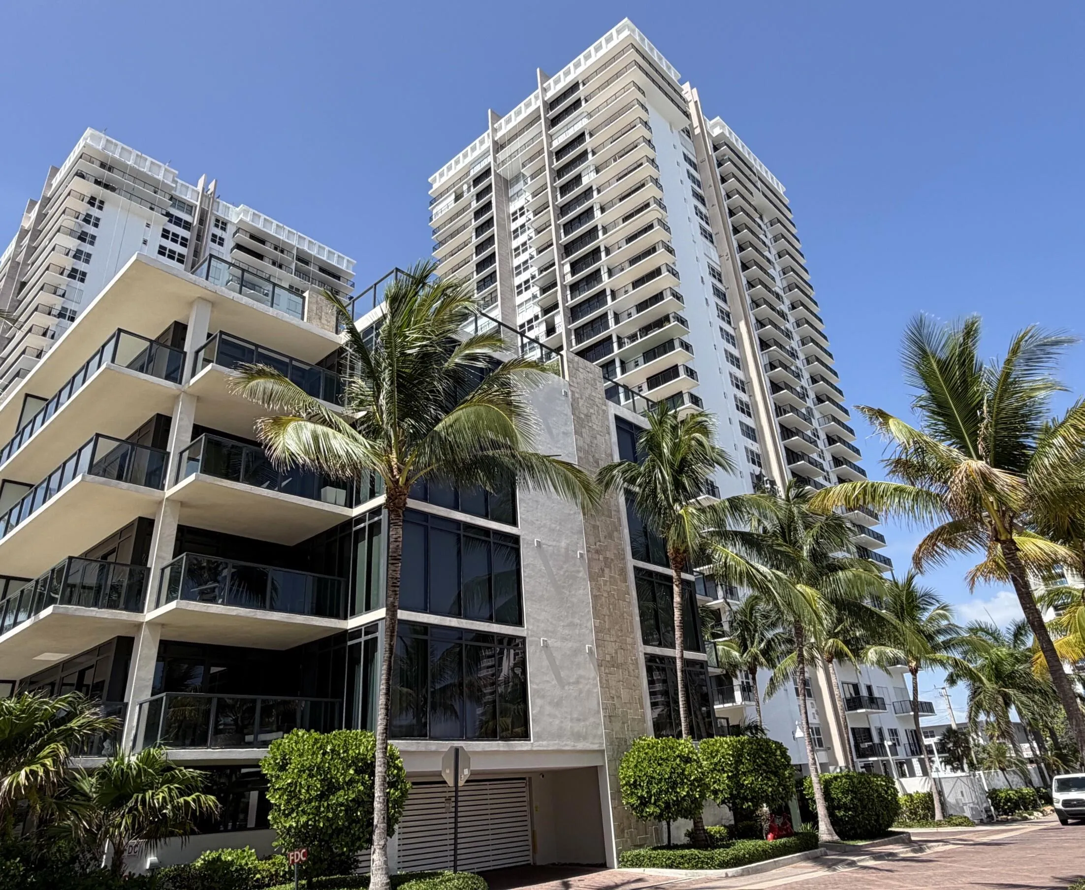Modern high-rise condominium featuring multiple private balconies with glass railings