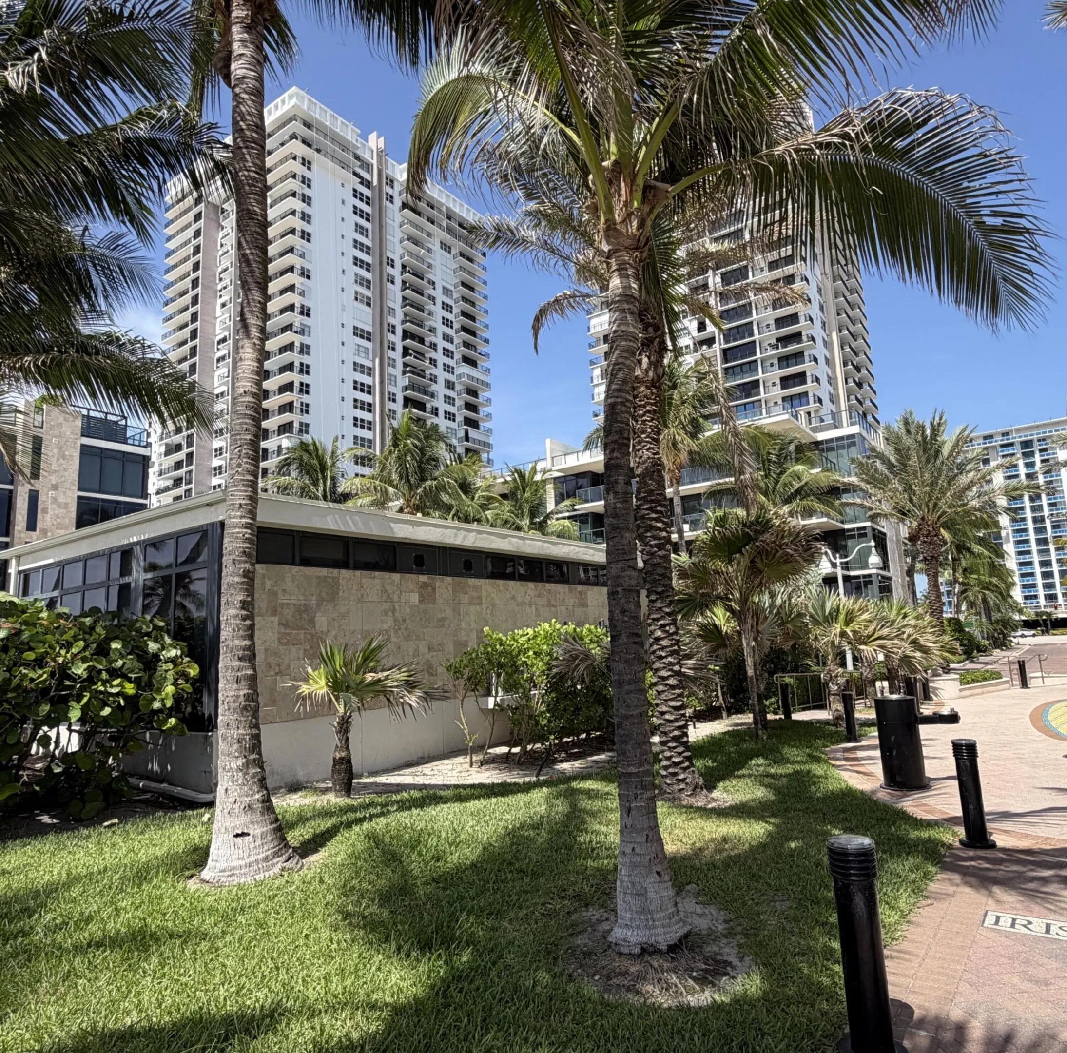 Lush tropical landscaping with manicured lawns and mature palm trees