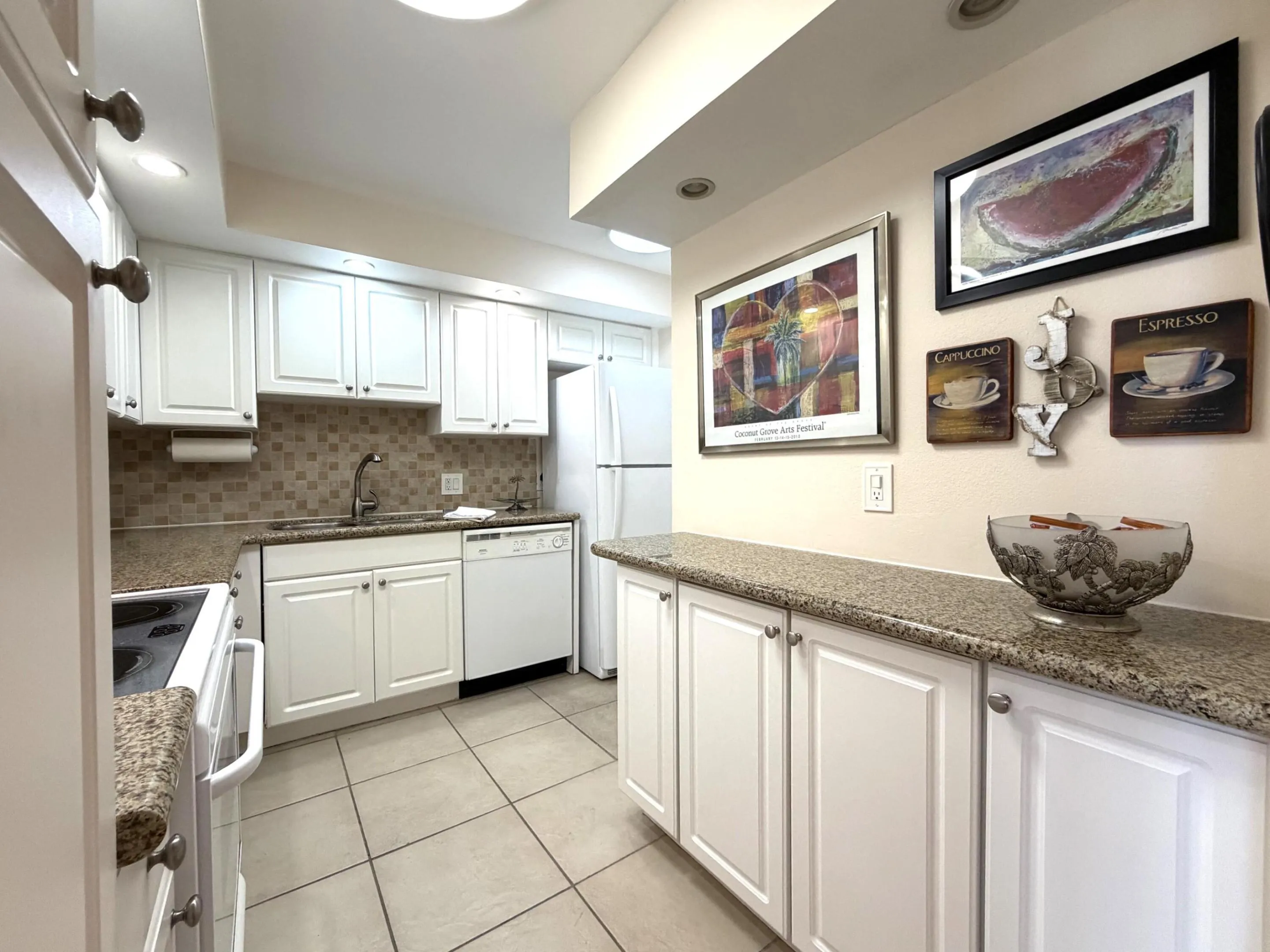 Kitchen featuring white cabinetry, granite-finish countertops, and a tiled backsplash