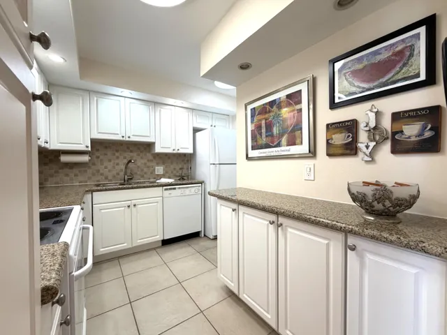 Kitchen featuring white cabinetry, granite-finish countertops, and a tiled backsplash