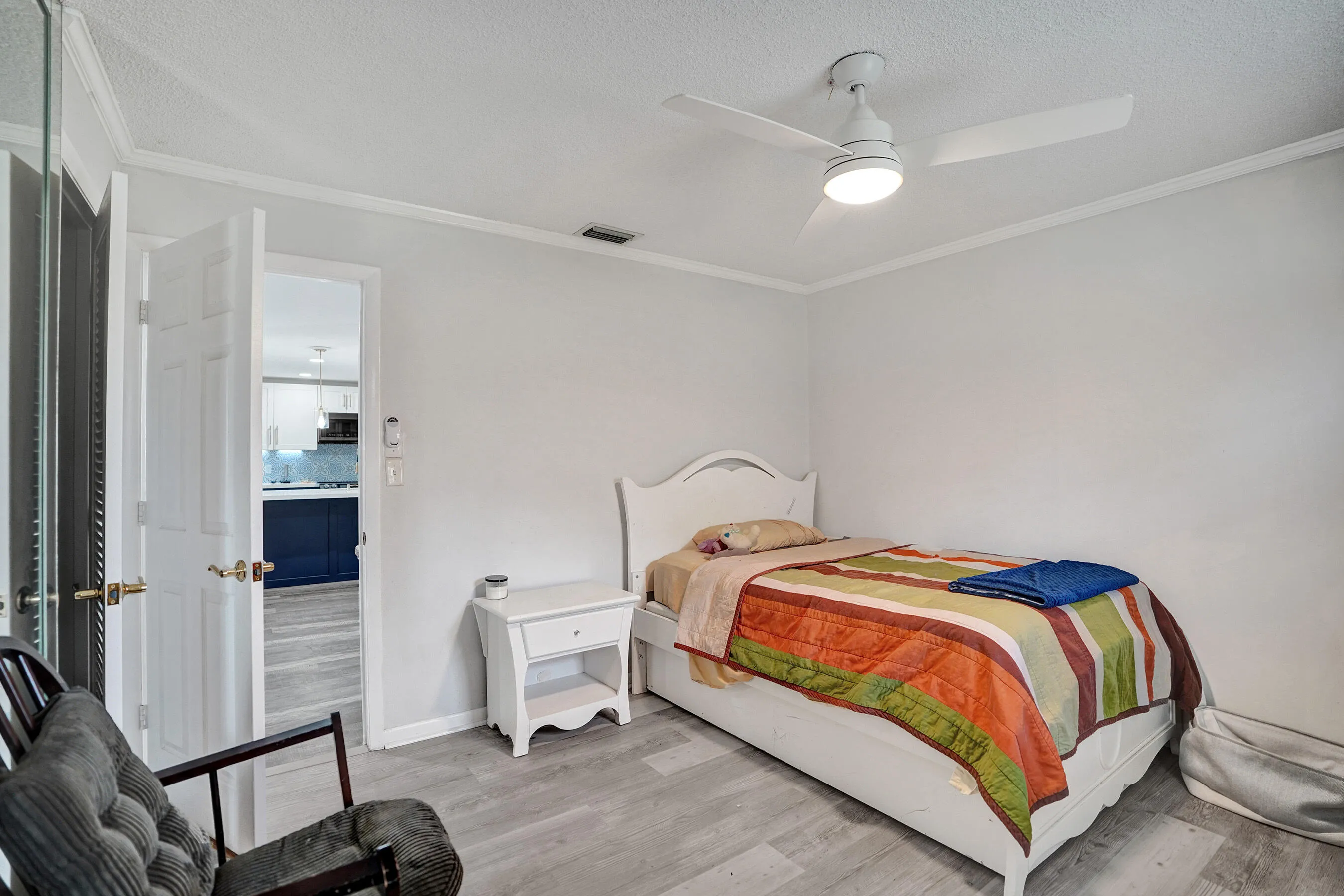 Room featuring light gray walls, wood-finish flooring, and crown molding