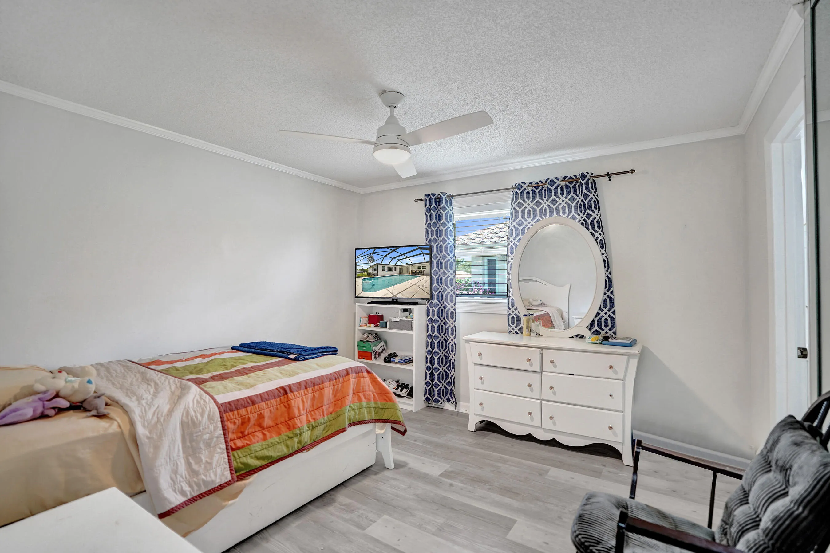 Interior room featuring light grey wood-finish flooring, white walls, and crown molding