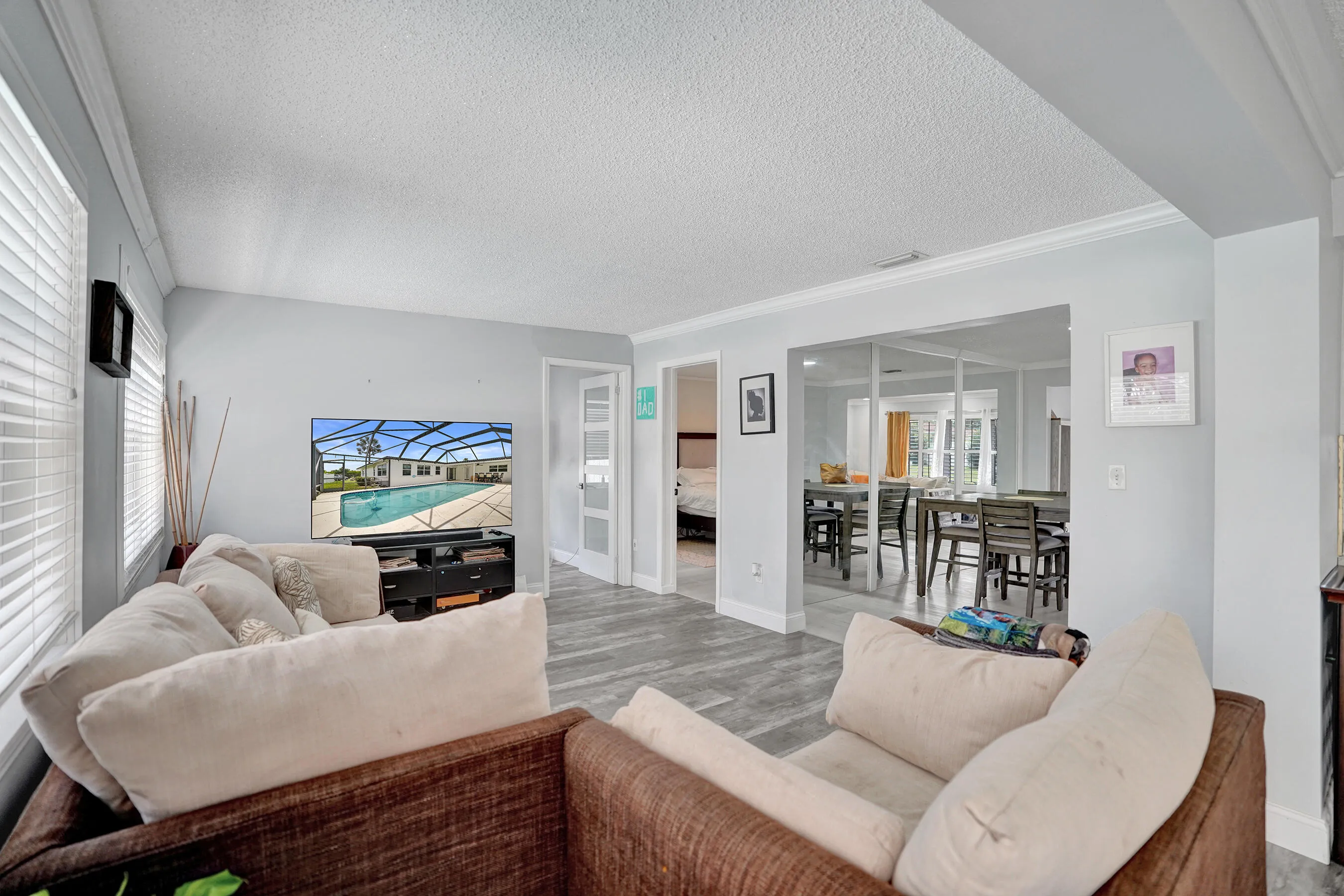 Open concept living space featuring wood-finish flooring and light-toned walls