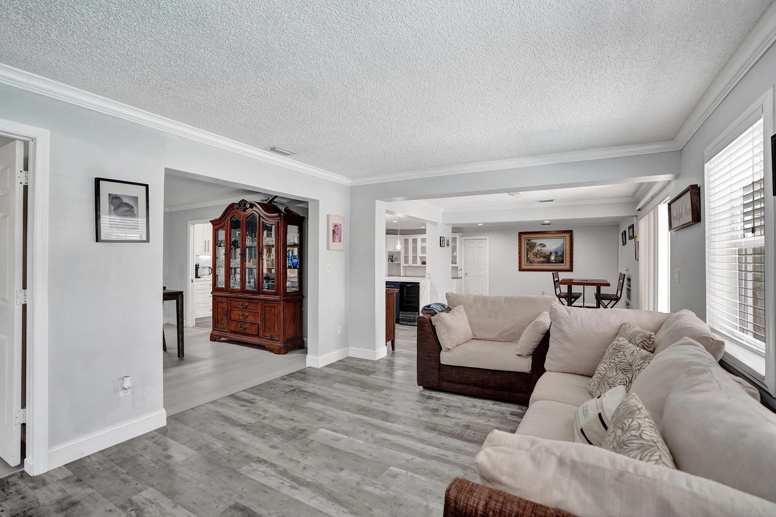 Bright interior space featuring wood-finish flooring, light-colored walls, and white crown molding