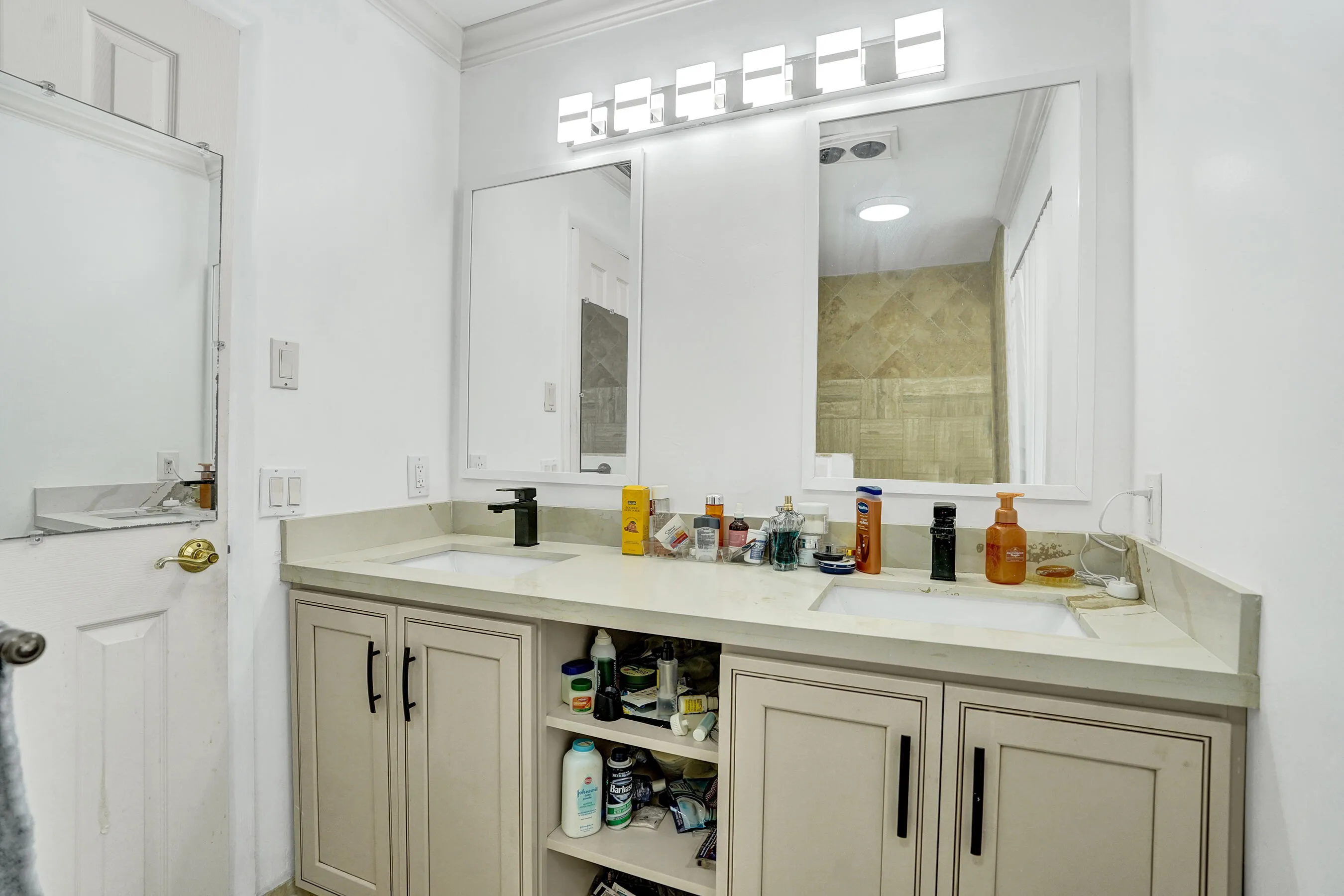 Double vanity with light-toned countertops and integrated sinks