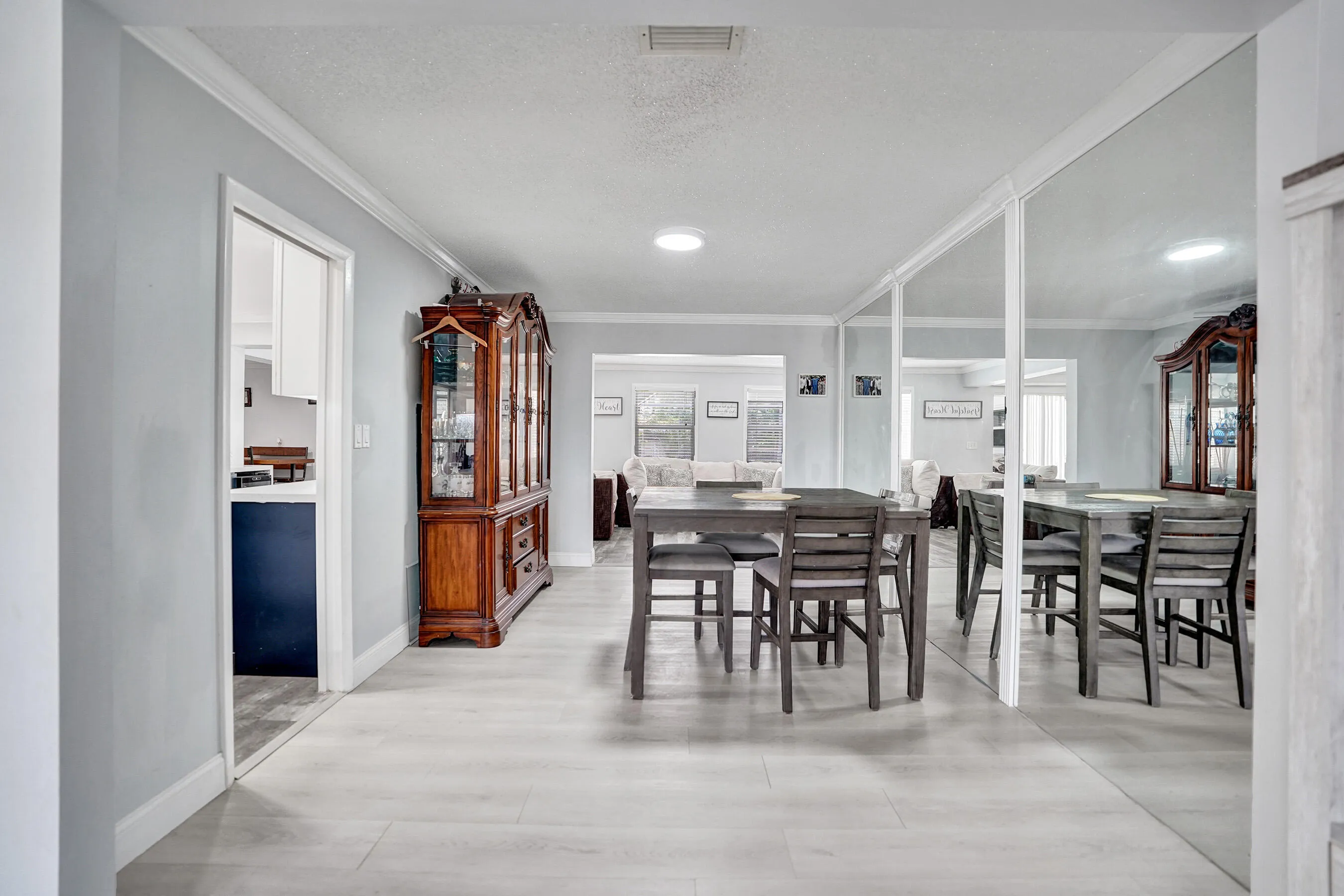Open concept living area featuring light wood-finish flooring, crown molding, and recessed lighting