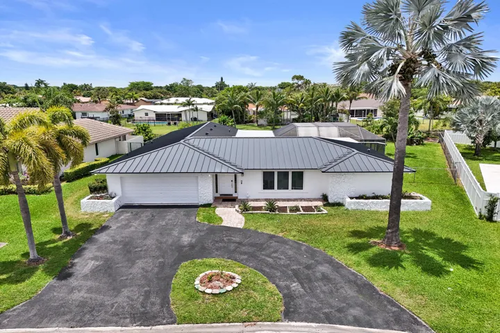 Contemporary single-story residence featuring a gray metal roof and white exterior