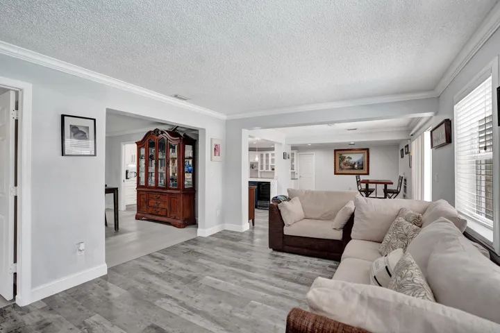 Bright interior space featuring wood-finish flooring, light-colored walls, and white crown molding