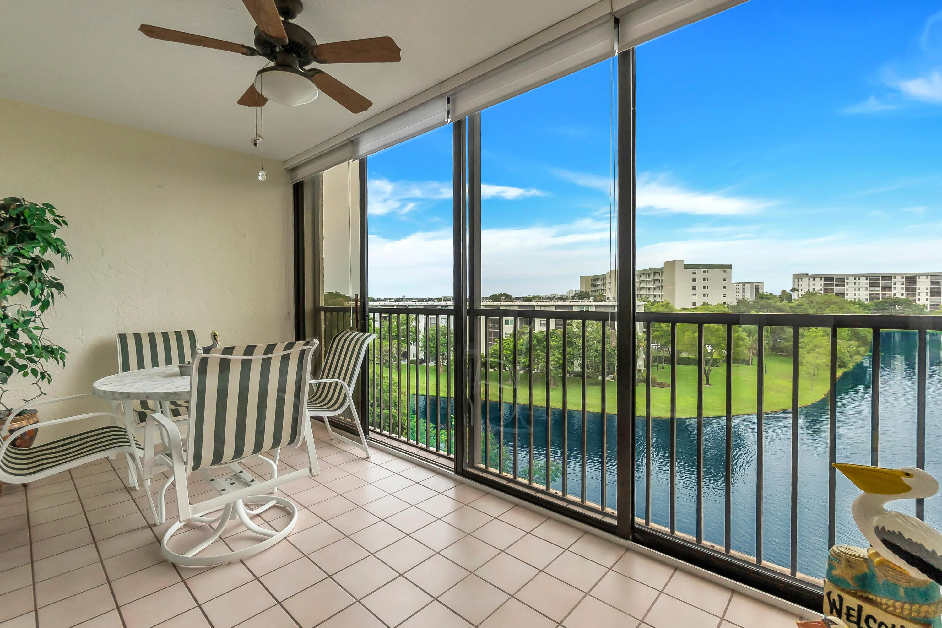 Large enclosed/screened balcony featuring a tiled floor, a ceiling fan and sliding door option.