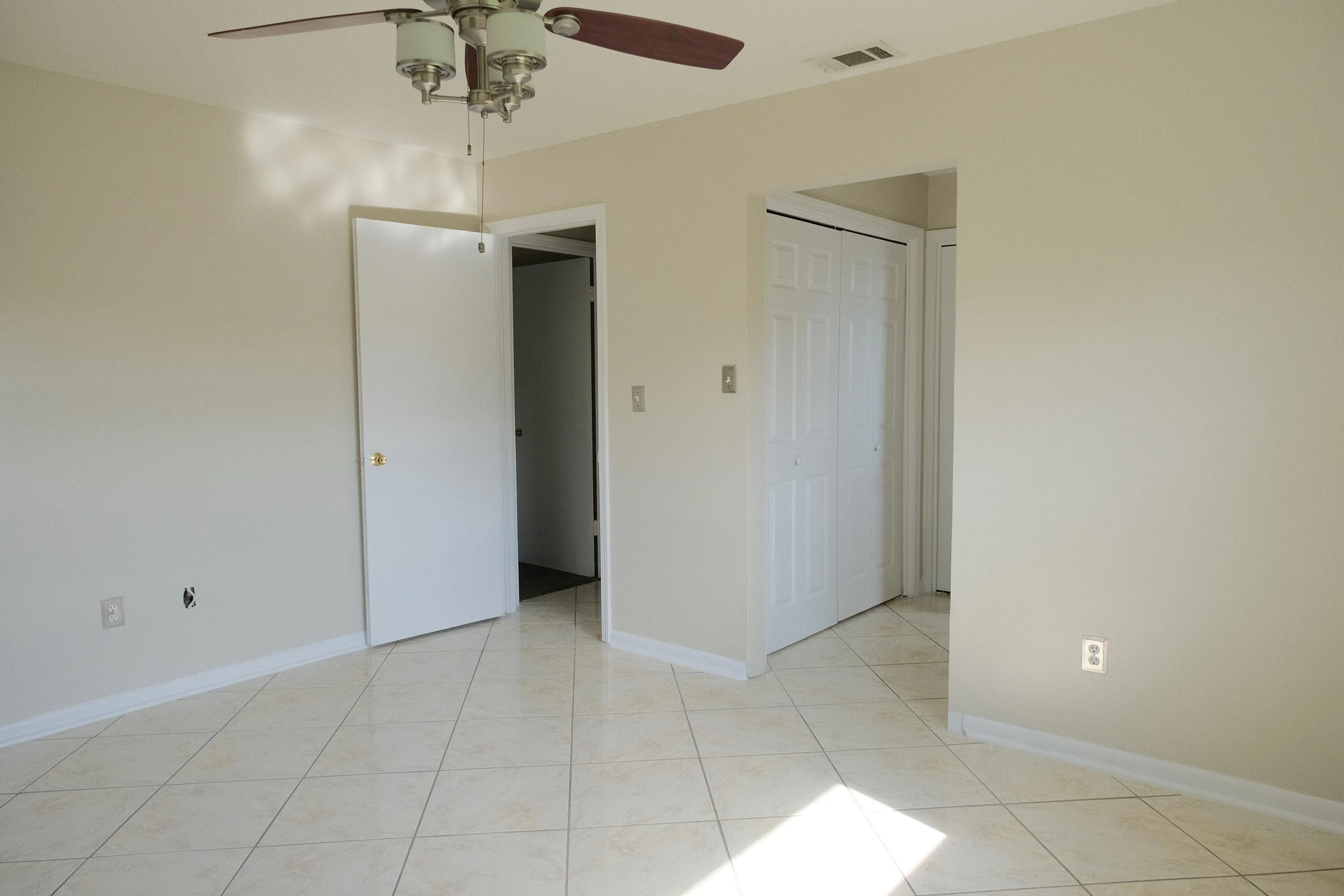 Spacious room featuring neutral painted walls, tile flooring, and white baseboards
