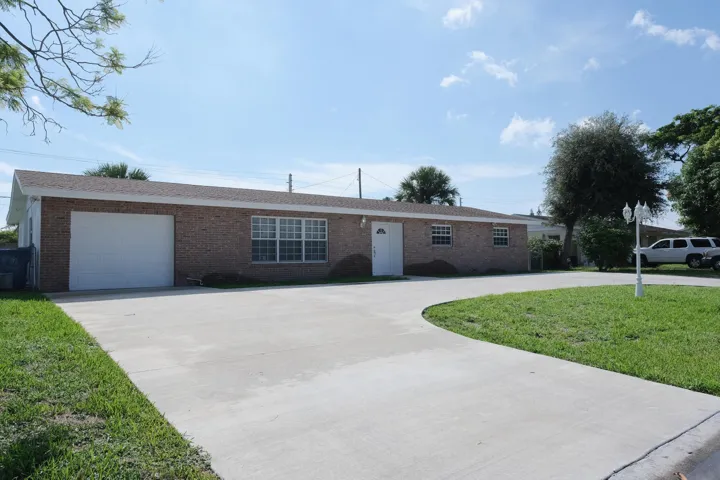 Brick exterior with a white garage door and complementary white entry door