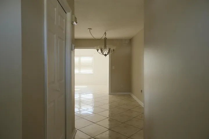 Central hallway featuring a built-in closet with bifold doors, leading to an open living area