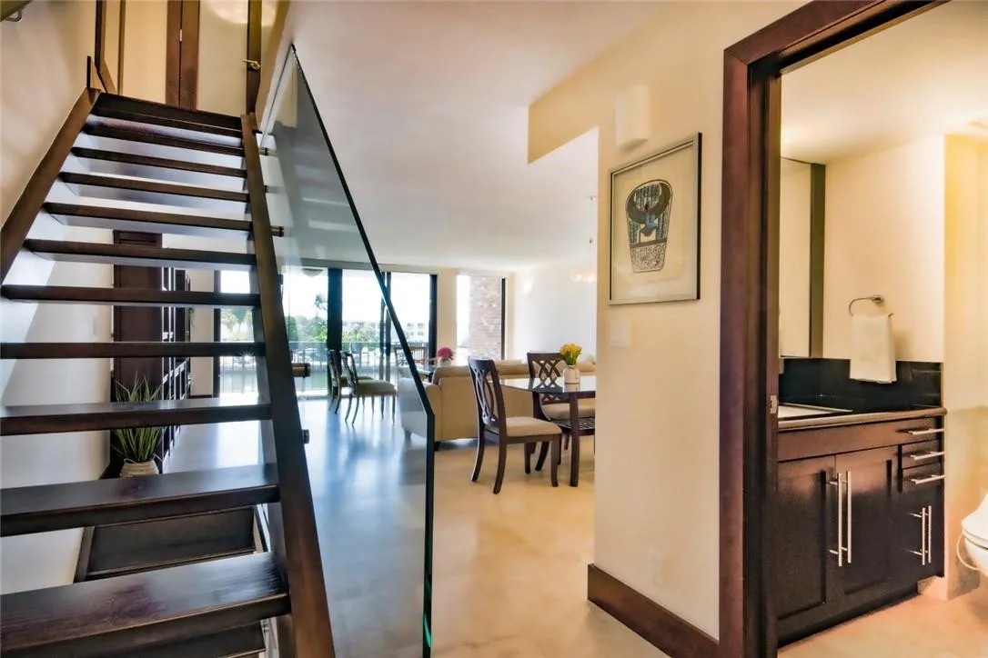View of the entry way with the stairs going to the third and the second levels, powder room on the right.